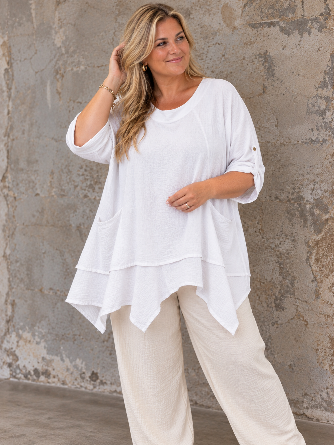 Lena Plus Size tunika i blød og let kvalitet med en flot, afslappet pasform. Tunikaen har rund hals, korte ærmer med opsmøg, praktiske lommer og en asymmetrisk kant, der falder smukt. Den løse facon gør den behagelig at have på og nem at style med både bukser, shorts og leggings. Fås i flere flotte farver og passer perfekt til plus size kvinder, der ønsker komfort og moderne stil.ai generet billed.