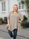 Smart tunika i en lækker bladningskvalitet af bomuld og hør. Denne model er specielt god til plus size kvinde kroppen, grundet den gode facon.

Billedet er genereret vha. AI.