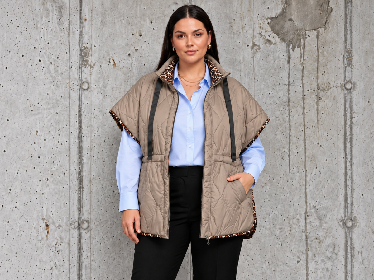 Leona quiltvest i beige til plus size med høj krave, leoparddetaljer, lynlås og lommer. Vist på model i str. 48.