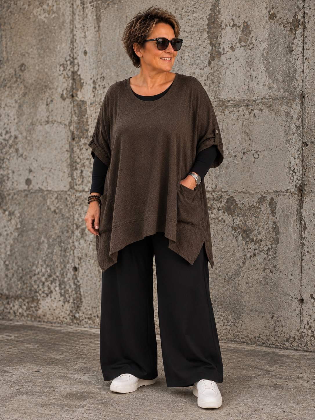 Lena Plus Size tunika i blød og let kvalitet med en flot, afslappet pasform. Tunikaen har rund hals, korte ærmer med opsmøg, praktiske lommer og en asymmetrisk kant, der falder smukt. Den løse facon gør den behagelig at have på og nem at style med både bukser, shorts og leggings. Fås i flere flotte farver og passer perfekt til plus size kvinder, der ønsker komfort og moderne stil.ai generet billed.