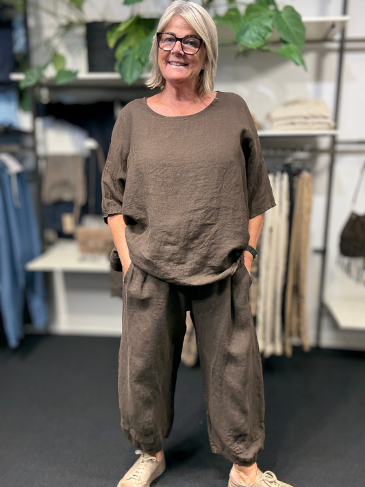 Det smarte hør sæt fra Sigensgaard, her i en smuk brun farve, perfekt til efteråret. Der er tilføjet et tørklæde for at give lidt ekstra farve. 