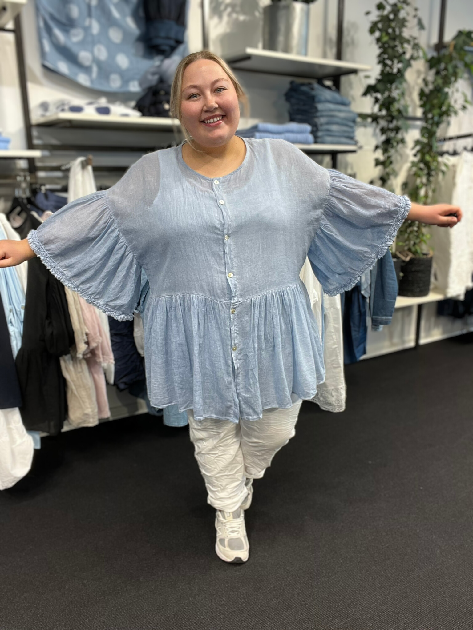 Plus size tunika i en let og tynd bomuld, som er perfekt til de varme dage. Tunikaen er i a-facon, som gør den ideel til plus size kvinder. Den er gennemknappet, så den kan bruges både åben og lukket. Her ses den i lys blå.