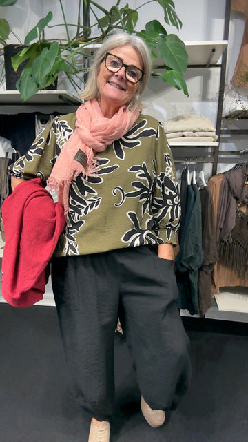 Mønstret plus size bluse med v-hals og flot rynke-detalje ved halsen. Den er med 3/4 ærmer, hvor der er smock afslutning, som gør at ærmet kan placeres hvor det lyster. Det giver også mulighed for at skabe ballon-effekt.