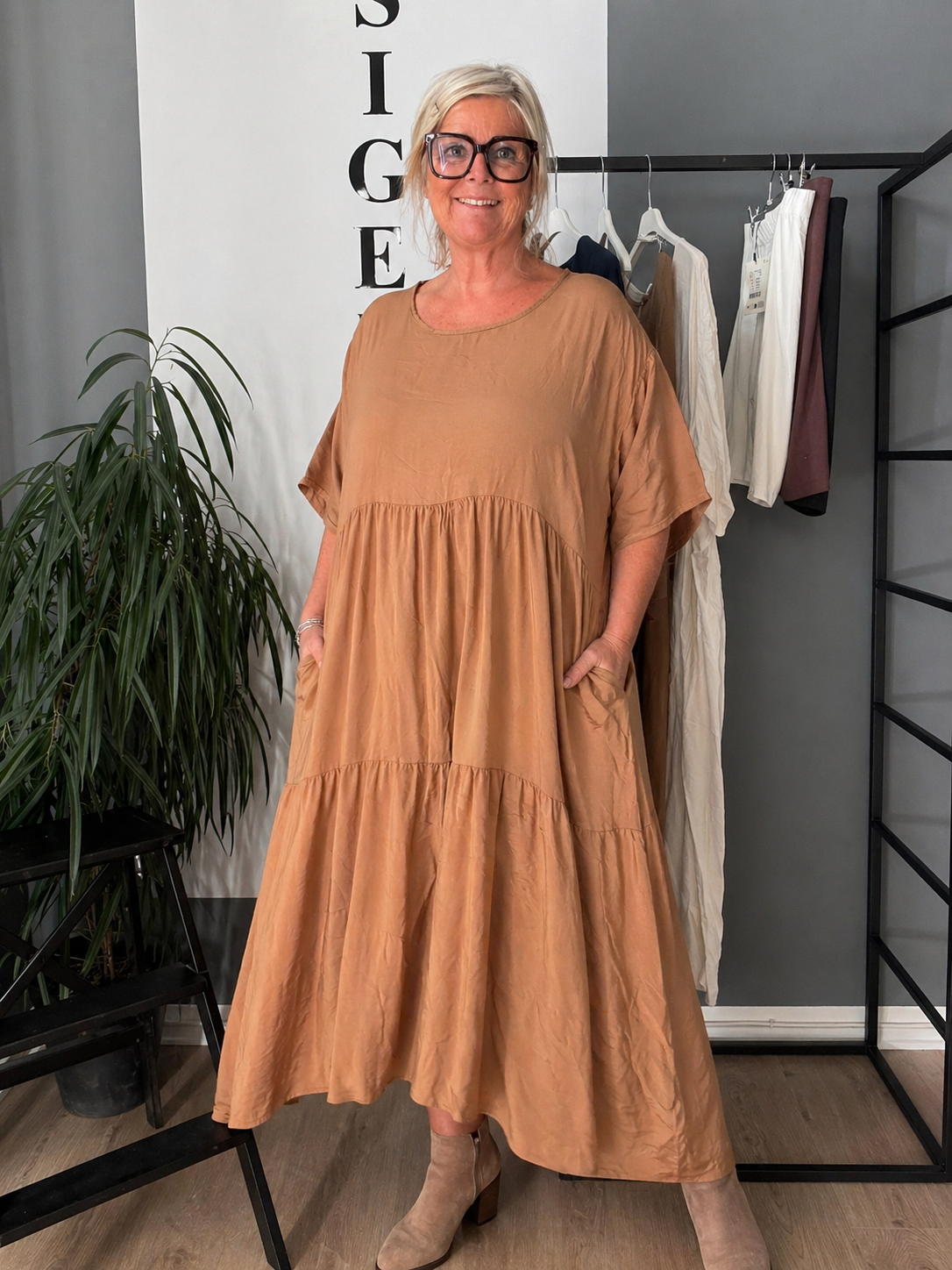 “Lolli kjole i ensfarvet – løs og luftig kjole i midi længde med korte ærmer og rund hals. Kjolen har en afslappet pasform med let rynk under brystet, der giver et feminint fald. Fremstillet i let materiale, perfekt til hverdagsbrug og komfort.