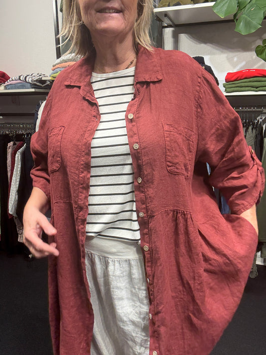 Smuk plus size tunika i den lækreste hør kvalitet. Den er i a-facon, som gør, at den er klædelig til de fleste pluspiger. 7/8 dels ærmer med elevatorhejs. Tunikaen kan bruges både åben og lukket. Her ses den i den flotte vinrøde farve.