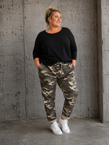 Den populære Lotte buks, nu med mere plads op over mave og numse. Den er til dig som fylder godt opover og gerne vil ha' lidt ekstra plads til dine lår.

Buksen er perfekt til plus size kvinden som elsker en camouflage buks med en god mængde stræk. 

Billedet er genereret vha. AI-teknologi for at vise buksen på en 