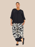 Smart plus size buks i zebra print med brede ben, lommer, elastik i livet og et bredt ensfarvet stykke ved buksens afslutning.
