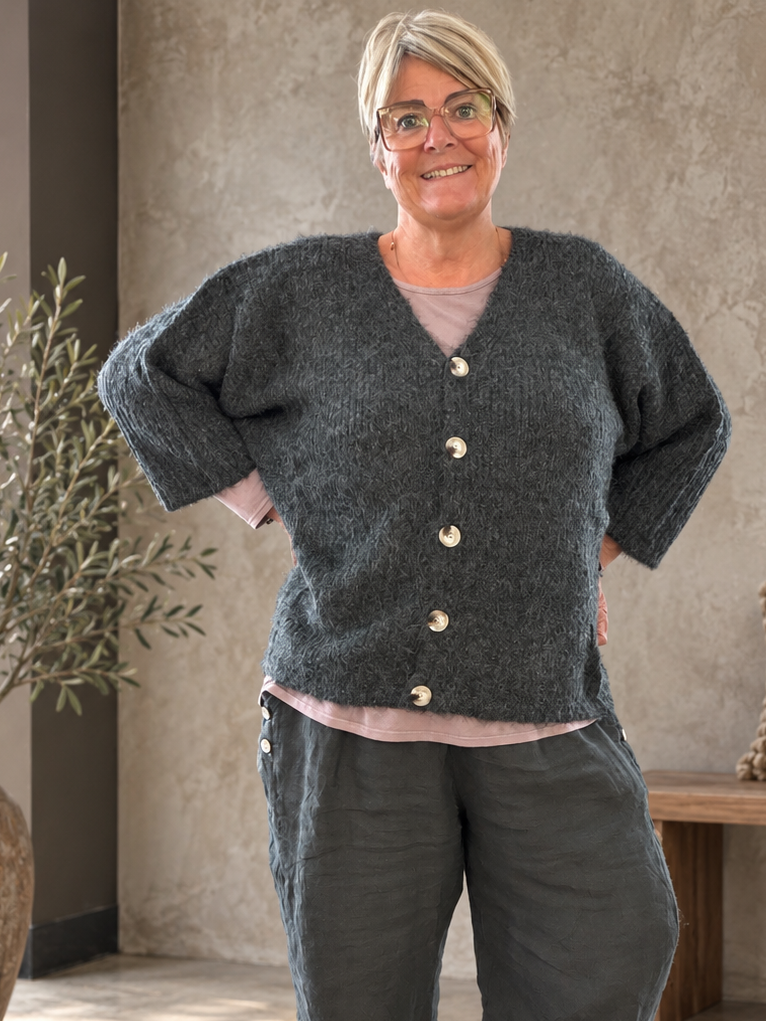 Lækker og blød strik perfekt til efteråret. Den er god til plus size kvinden som elsker noget afslappet men smart. Den er perfekt til dine lag-på-lag looks. 

Billedet er delvist AI-genereret. 