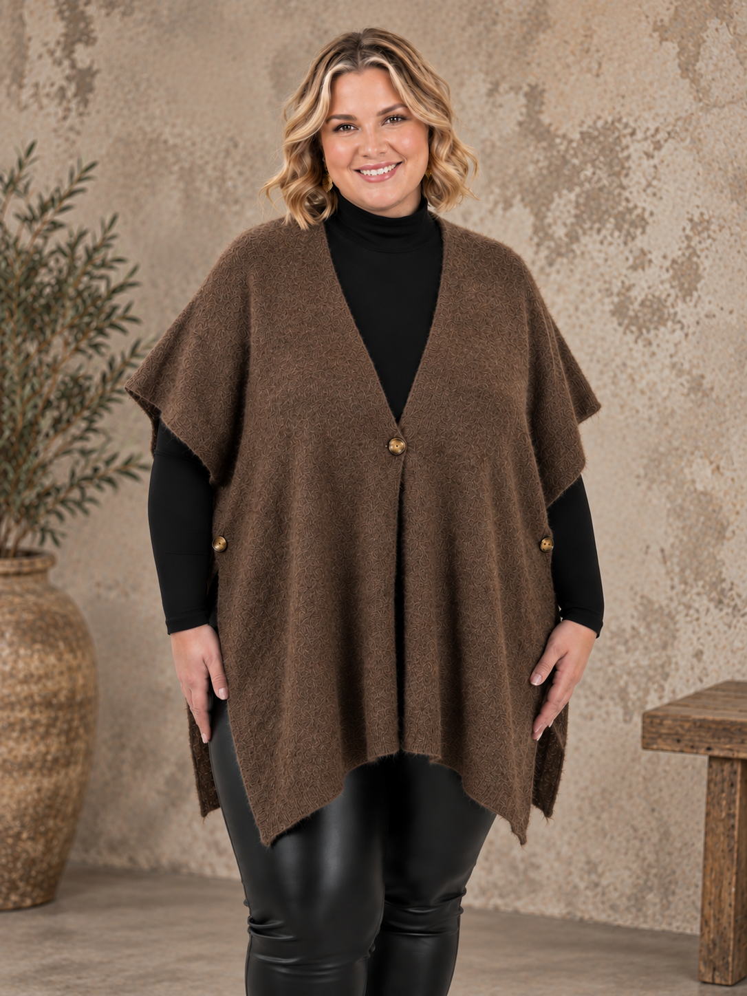 Smart plus size poncho i strik. Den er med flotte knapdetaljer og et perfekt til lag-på-lag looks. 