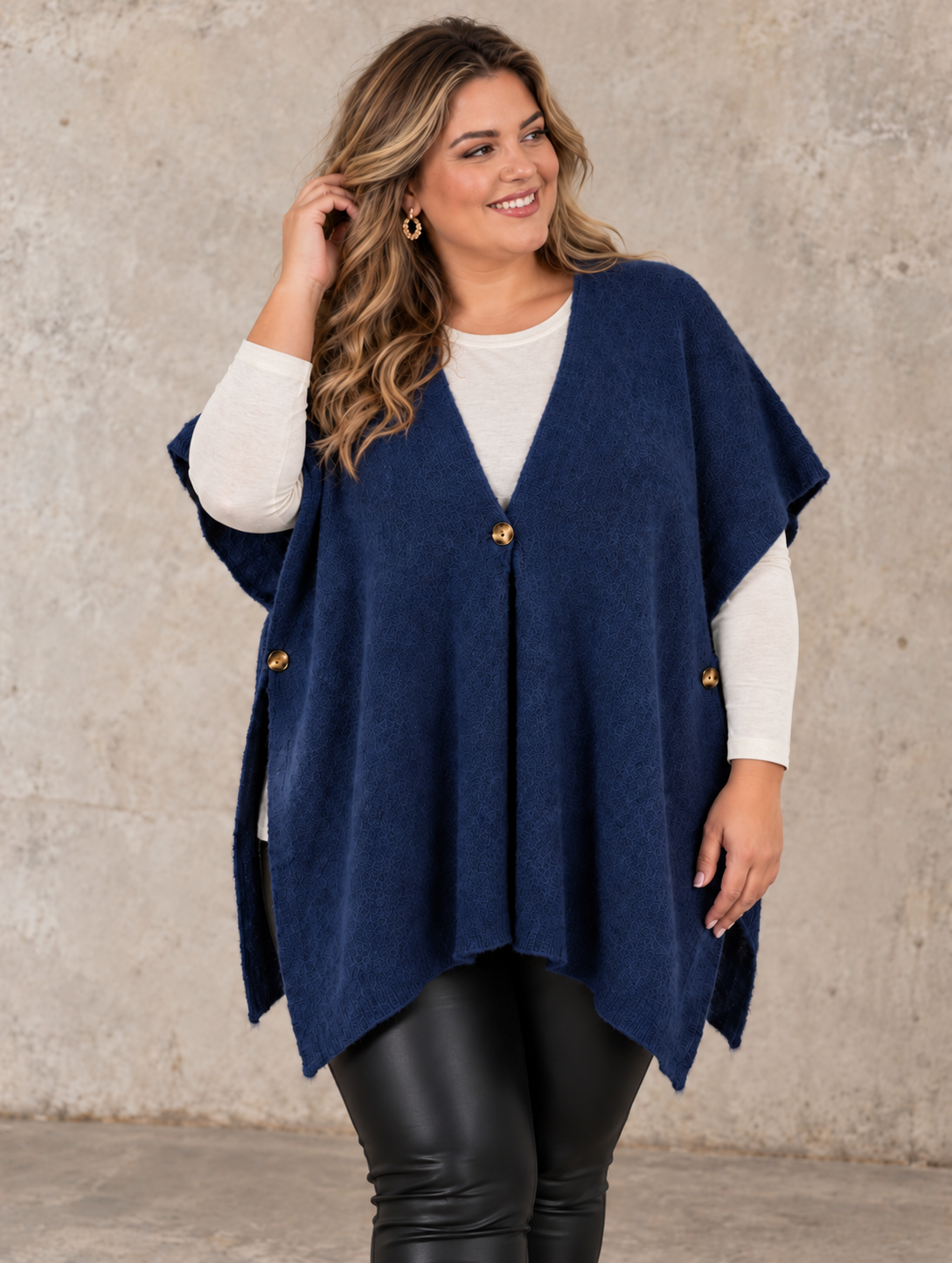 Smart plus size poncho i strik. Den er med flotte knapdetaljer og et perfekt til lag-på-lag looks. 