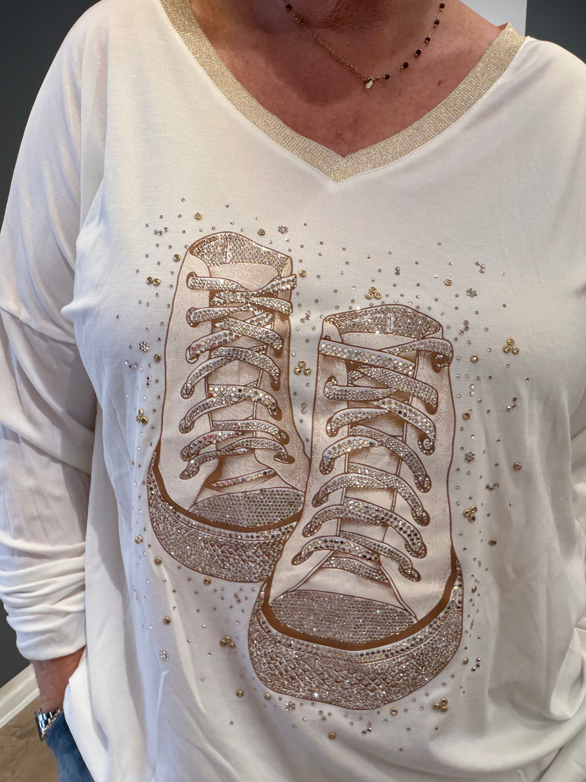 Mila T-shirt med V-hals og strikkant, lange ærmer og flot sko-print på fronten. Blød og stretchy viskosekvalitet med tætsiddende pasform.