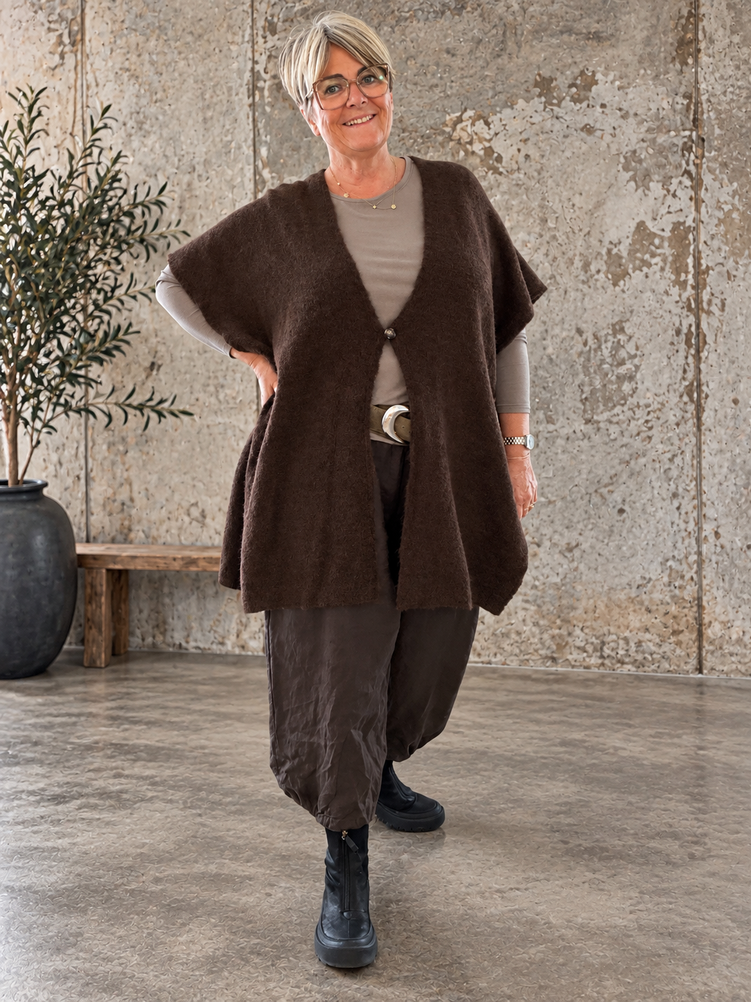 Smart plus size poncho i strik. Den er med flotte knapdetaljer og et perfekt til lag-på-lag looks. 