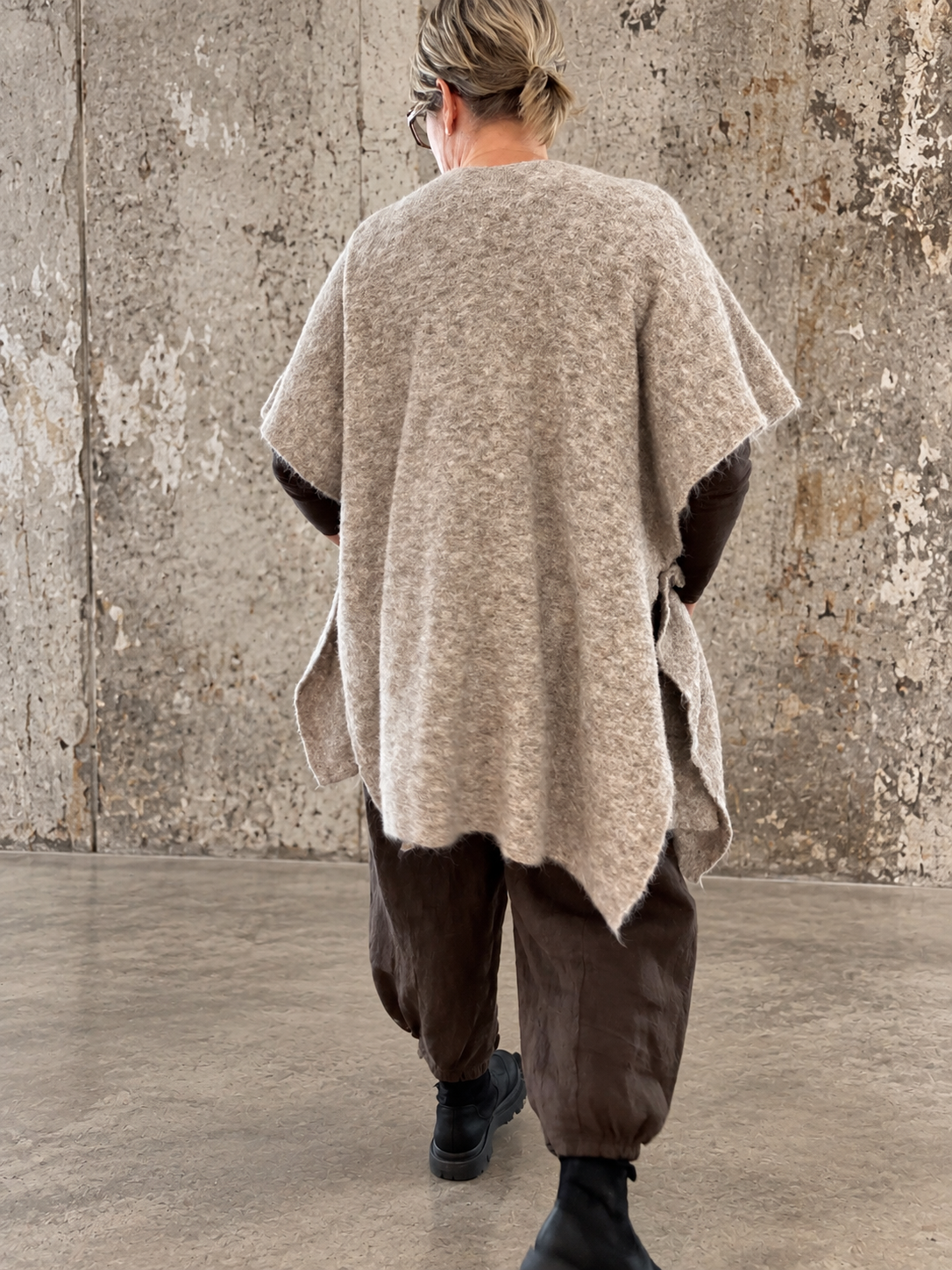 Smart plus size poncho i strik. Den er med flotte knapdetaljer og et perfekt til lag-på-lag looks. 