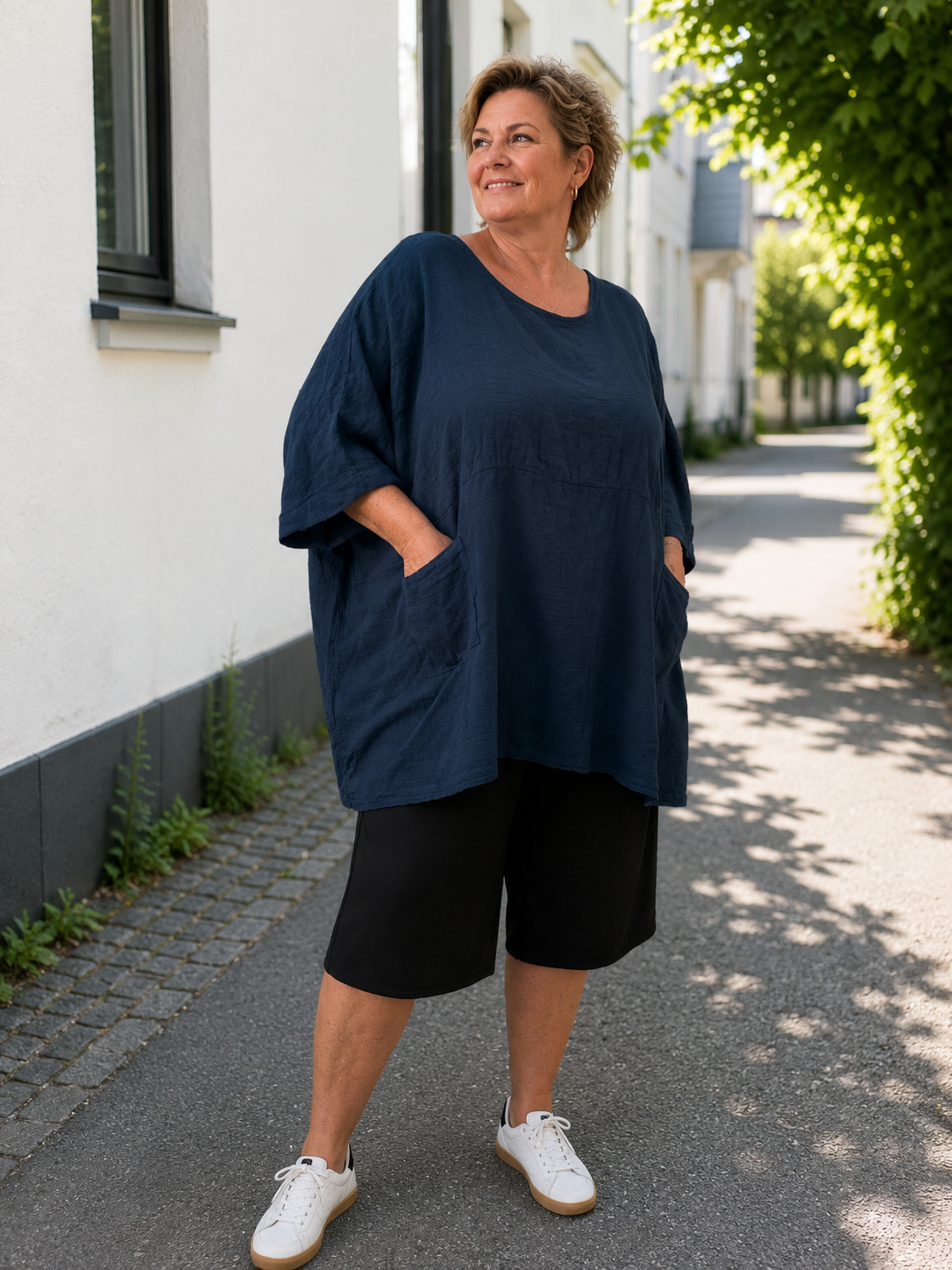 **Alt-tekst – Susanne plussize bomuldstunika (AI-genereret billede):**

AI-genereret billede af en smilende plus-size model iført Susanne bomuldstunika i mørk brun. Tunikaen har en løs, oversize pasform med rund hals, korte brede ærmer og store påsyede lommer foran. Den er stylet med rustfarvede bukser og komfortable sko i et råt industrielt miljø, som fremhæver tunikaens afslappede og moderne udtryk. Ideel til kvinder, der ønsker komfort, bevægelsesfrihed og et stilfuldt hverdagslook.

