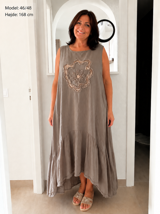 Mie Kjolen er en smuk og feminin kjole med et afslappet boheme-look og en skøn rummelig pasform. Kjolen falder flot omkring kroppen og giver et elegant, let og komfortabelt udtryk.Ai generet billed
