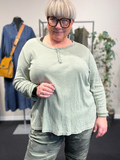 Plus size t-shirt med langt ærme, rund hals med stolpe ned i knaplukning, vask er stone wash hvilket betyder at farver er uens. Den er i en lækker bomuldskvalitet, som er åndbar og god at have under noget andet.