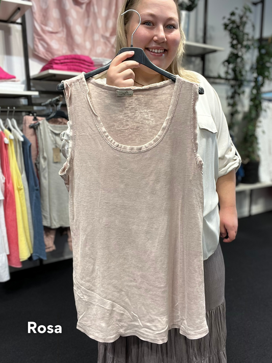 Rå bomulds top med rund hals, til plus size pigen, som ønsker en anvendelig top. Den er i stone vasket bomuld, så farven er uens i stoffet, hvilket giver et råt look, sammen med de i forvejen rå kanter ved hals og ærme. Toppen her passes af mange grundet den gode kvalitet. 