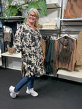 Smart plus size tunika i unikt print. Den er med lange ærmer, v-hals og så er der smock-detalje ved ærmets afslutning. Fra str. 42 til og med str. 58.