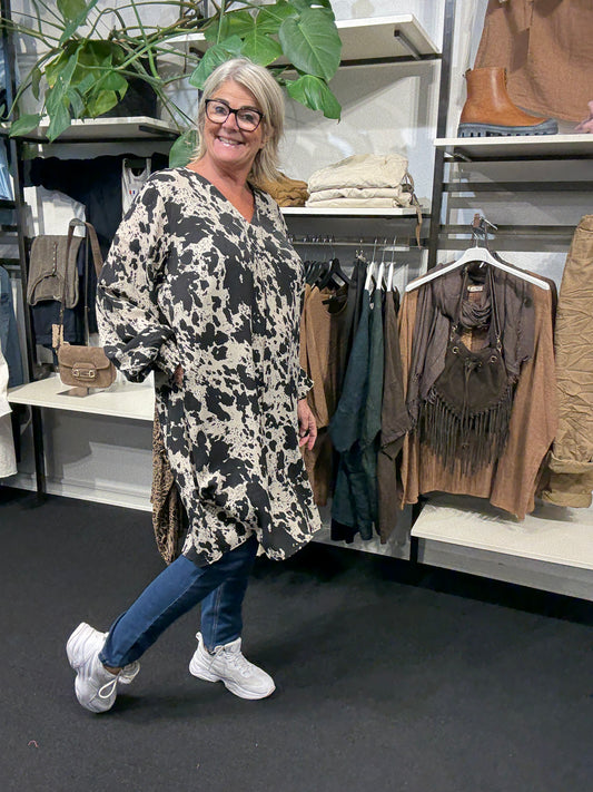 Smart plus size tunika i unikt print. Den er med lange ærmer, v-hals og så er der smock-detalje ved ærmets afslutning. Fra str. 42 til og med str. 58.