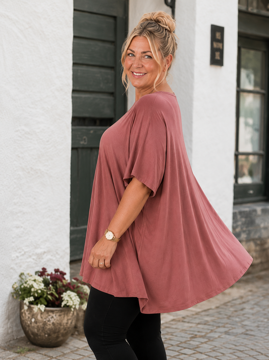 Pernille viskose T-shirt i A-shape med løs og luftig pasform, vist på model der er 168 cm høj og bruger størrelse 46/48. T-shirten er i en mørkebrun nuance og har korte, brede ærmer samt en flatterende V-hals, der giver et afslappet og feminint look. Den falder flot over kroppen og giver god bevægelsesfrihed, hvilket gør den ideel til både hverdag og komfortabel styling.

Billedet er genereret vha. AI-teknologi for at vise t-shirten på en person.