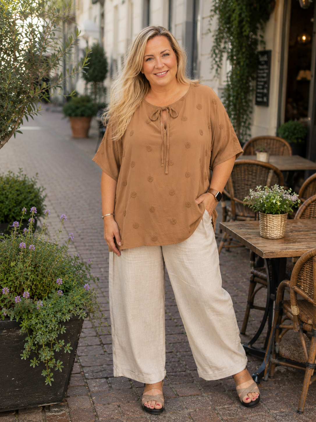 Pippi tunikaen er med sin tynde kvalitet og korte ærmer den perfekte tunika til sommeren. Den er smart med sine prikker og den finde detalje med bindbånd i hals. En smart plus size tunika du vil bruge år efter år. 

Billedet er genereret vha. AI-teknologi for at vise tunikaen på en person.