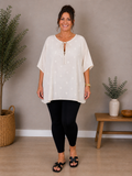 Den lækre plus size tunika i 100% bomuld. Den er smart med prikkerne og snøre ved halsen. 

Billedet er genereret vha. AI.