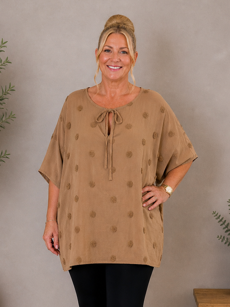 Den lækre plus size tunika i 100% bomuld. Den er smart med prikkerne og snøreved halsen. 

Billedet er genereret vha. AI.