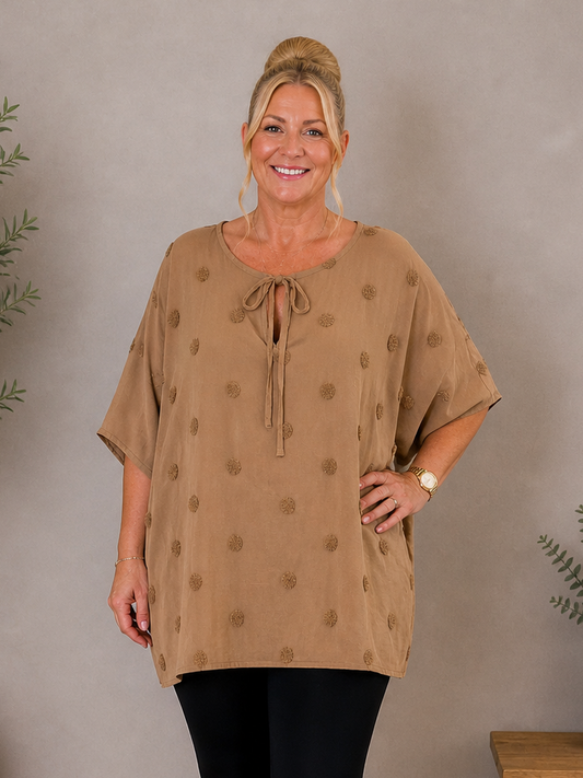 Den lækre plus size tunika i 100% bomuld. Den er smart med prikkerne og snøreved halsen. 

Billedet er genereret vha. AI.
