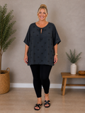 Den lækre plus size tunika i 100% bomuld. Den er smart med prikkerne og snøre ved halsen. 

Billedet er genereret vha. AI.