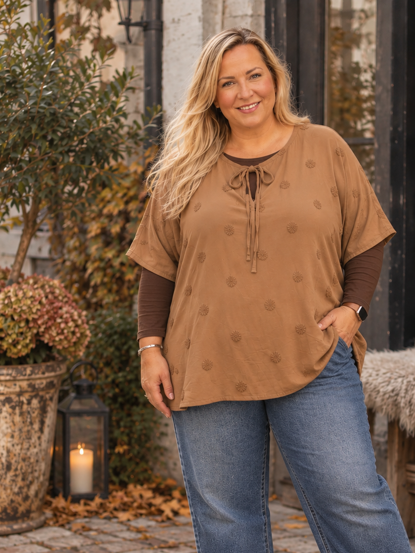 Pippi tunikaen er med sin tynde kvalitet og korte ærmer den perfekte tunika til sommeren. Den er smart med sine prikker og den finde detalje med bindbånd i hals. En smart plus size tunika du vil bruge år efter år. 

Billedet er genereret vha. AI-teknologi for at vise tunikaen på en person.