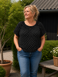 Prik t-shirten fra Sigensgaard. Den er med elastik ved halsen og så er den i en dejlig tynd kvalitet, som er perfekt til sommervejret. 

Billedet er genereret vha. AI teknologi, for at vise blusen på en person. 