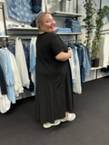 Lækker viskose kjole, som er perfekt til plus size pigen, der elsker tøj som kan bruges til både hverdag og fest. Denne kjole kan dresses op og ned alt efter lejlighed. Her ses den i sort.