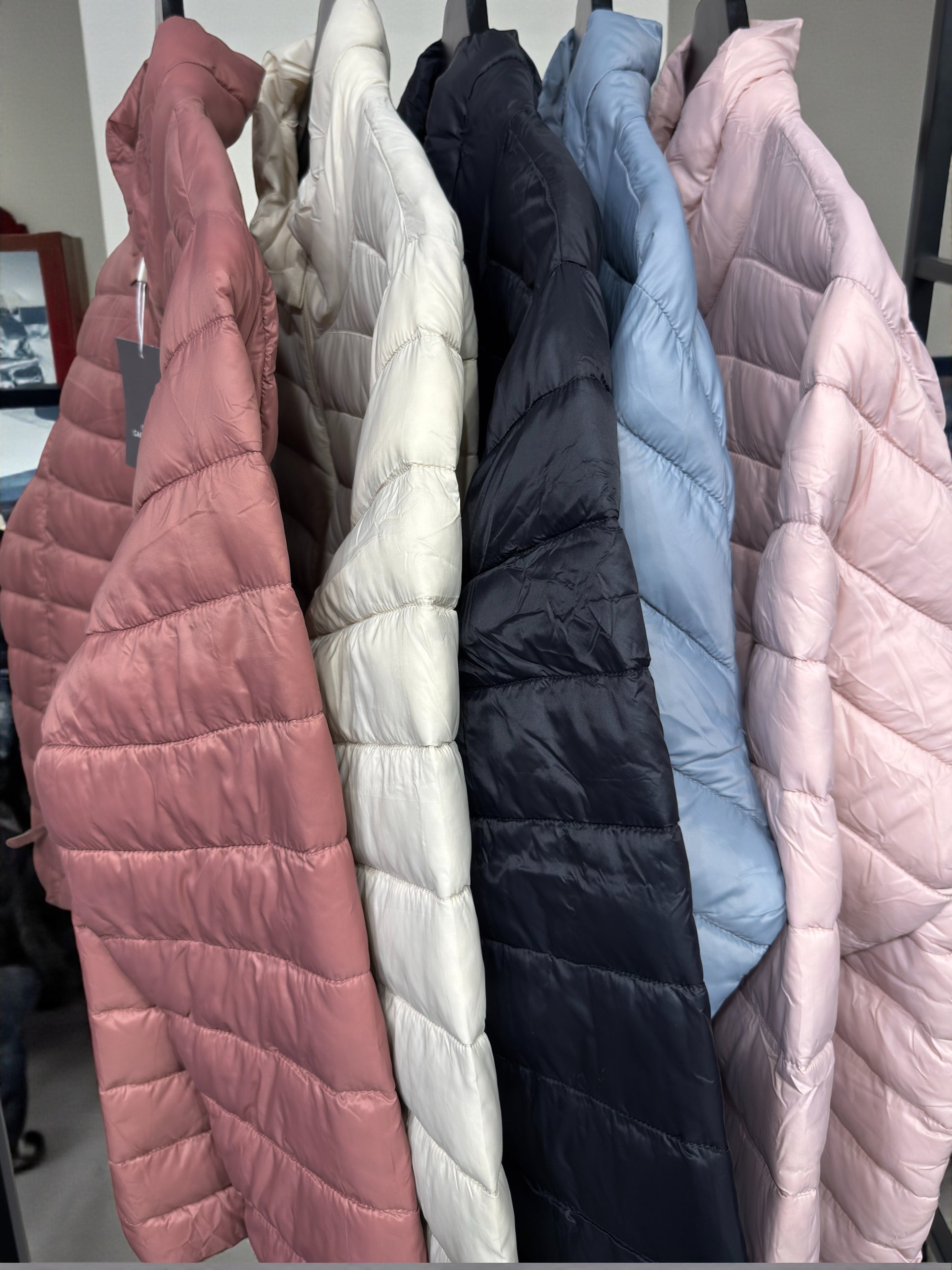 Jakken har høj hals, lange ærmer, lynlås foran og praktiske sidelommer med lynlås. Den er let foret med blød, syntetisk fyld, som giver god varme uden at virke tung.