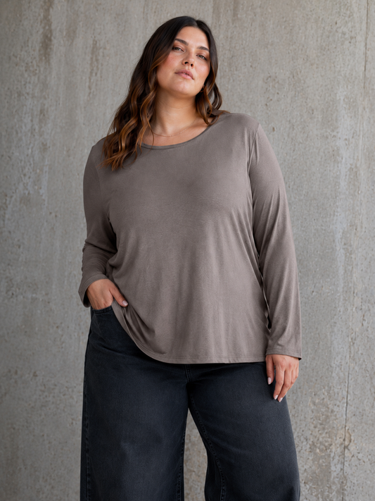 Alli plus size T-shirt med lange ærmer, rund hals og afslappet pasform – perfekt som blød basisbluse under skjorter, strik, veste og jakker.
Billed er Ai generet.