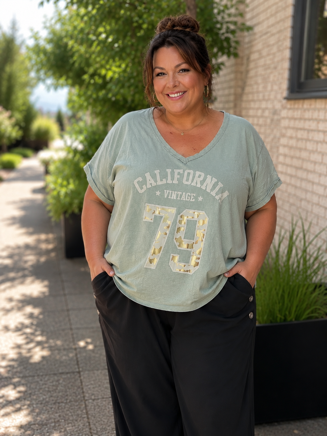 Kate T-shirten er den perfekte hverdagsfavorit med et moderne og afslappet look. Den bløde kvalitet, den flotte V-hals og det trendy California Vintage-print giver et råt udtryk, som er nemt at style til både jeans, hørbukser og shorts.

Den løse pasform falder flot over kroppen uden at stramme og gør T-shirten behagelig at have på hele dagen. De opsmøgede ærmer giver et smart finish, mens det lette materiale gør den ideel til både sommer og som lag under en cardigan eller jakke.

billed er ai generet