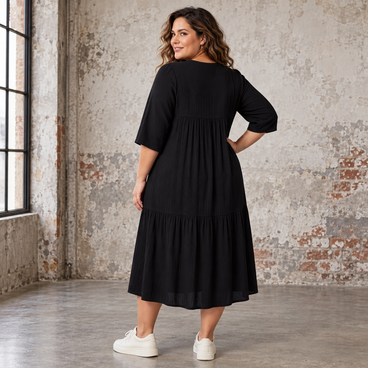 "Rigmor plussize-kjole med flot A-facon, flere lette lag, forlænget ryg og to diskret placerede lommer foran, der virker slankende."