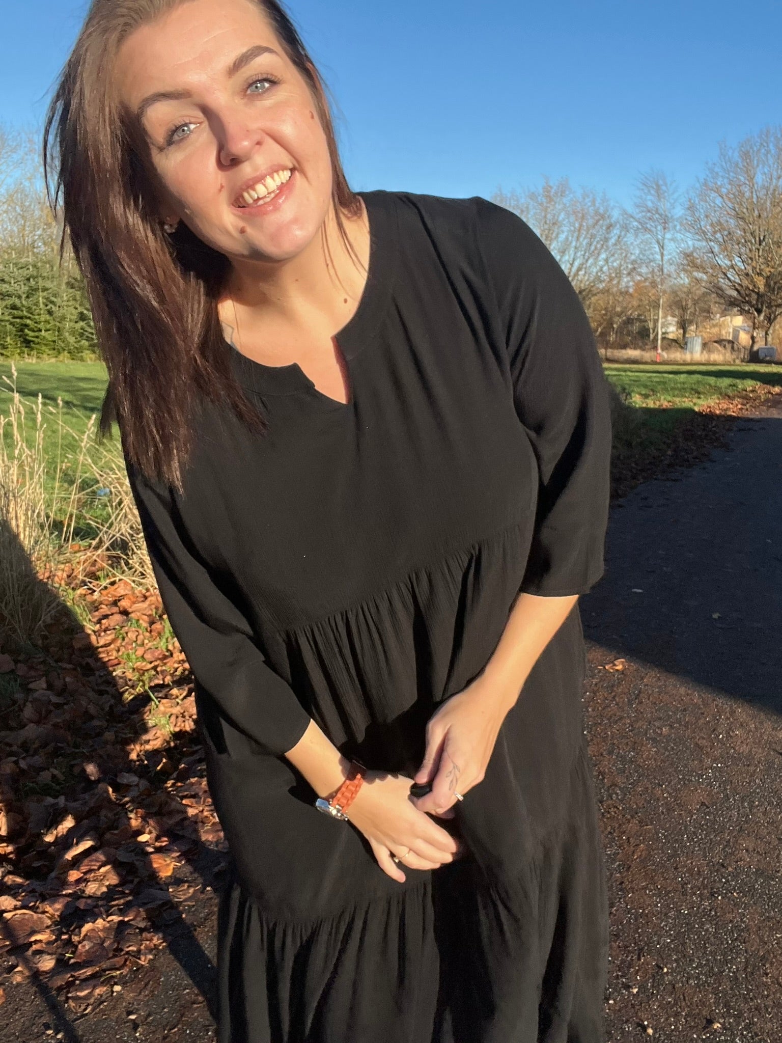 "Rigmor plussize-kjole med flot A-facon, flere lette lag, forlænget ryg og to diskret placerede lommer foran, der virker slankende."