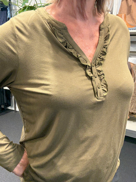 Flot plus size bluse med v-hals og stolpelukning hvor der er påsat flæsekant, som giver et feminint udtryk.kvalitet er jersey så den er blød og lækker