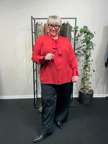 Smuk og feminin plus size bluse, perfekt til både hverdag og fest. Den er med et bindebånd foran, som man kan lade hænge eller binde til en sløjfe eller anden knude.