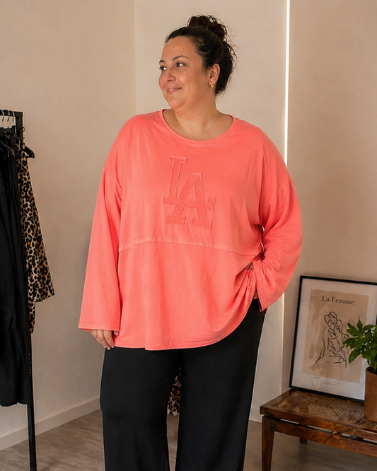 Billedet er af en AI-genereret model, hvor hun har vores Ruth sweatshirt på i coral. 