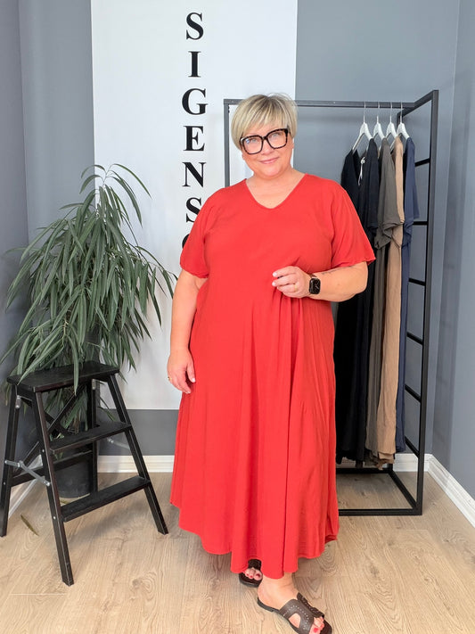 “Pernille plussize viskose kjole i smuk A-facon. Modellen er 168 cm høj og bruger størrelse 46/48. Kjolen har korte ærmer, V-udskæring og et løstsiddende, flatterende fald i mange flotte farver billed er Ai generet