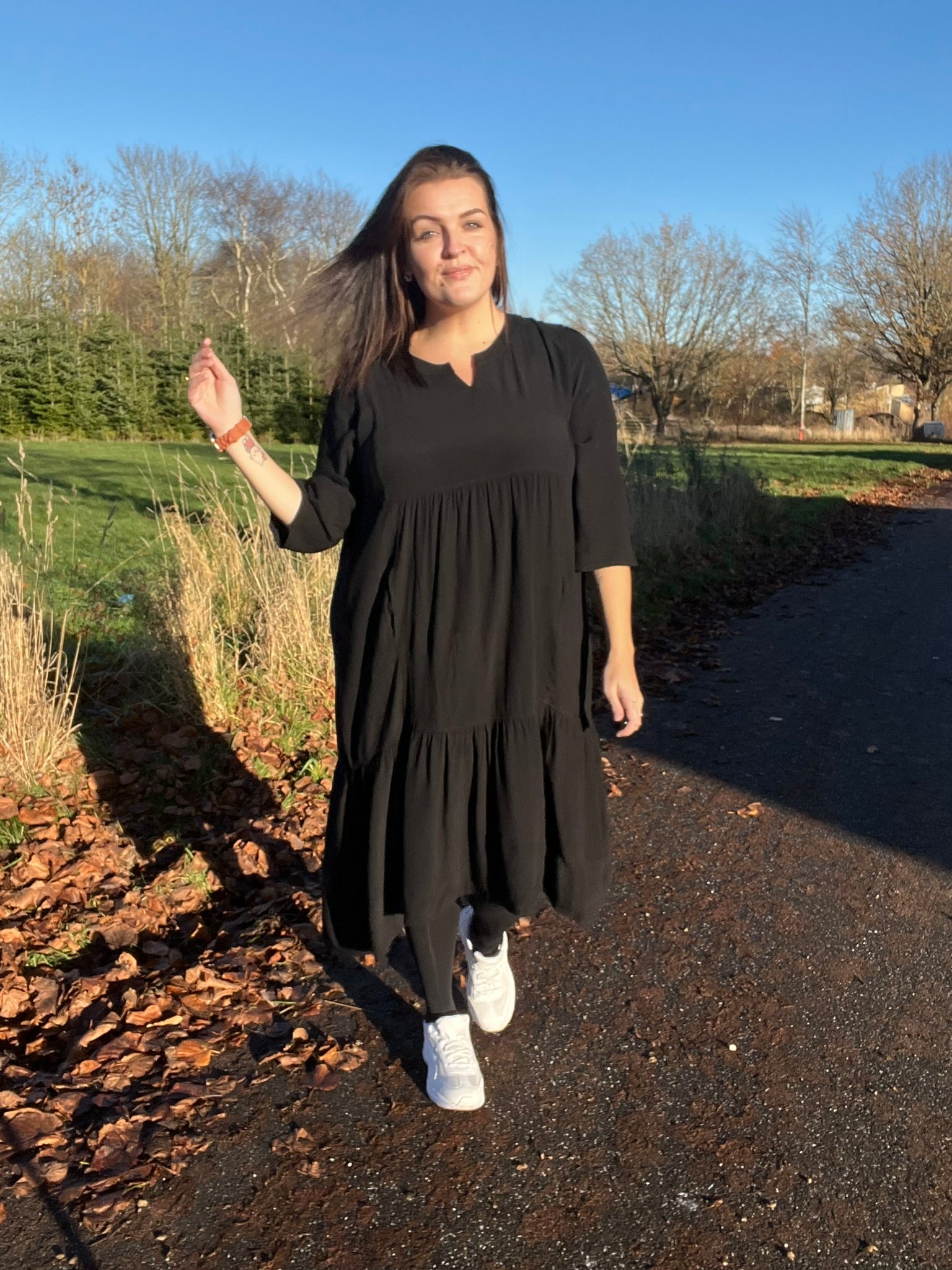 "Rigmor plussize-kjole med flot A-facon, flere lette lag, forlænget ryg og to diskret placerede lommer foran, der virker slankende."