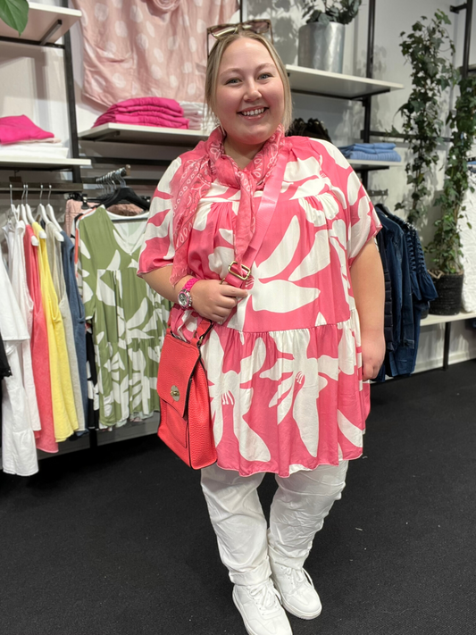Plus size tunika i den gode a-facon, som man aldrig går fejl af. Den er med smart print, og fås i flere forskellige farver. Den er med korte ærmer og overskæring på brystet.