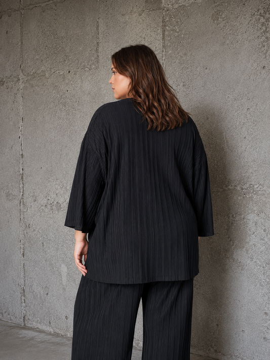 En brugbar plus size bluse med rund hals og 7/8 ærmer. Den er i en flot kvalitet, som fungerer godt til både hverdag og fest. 