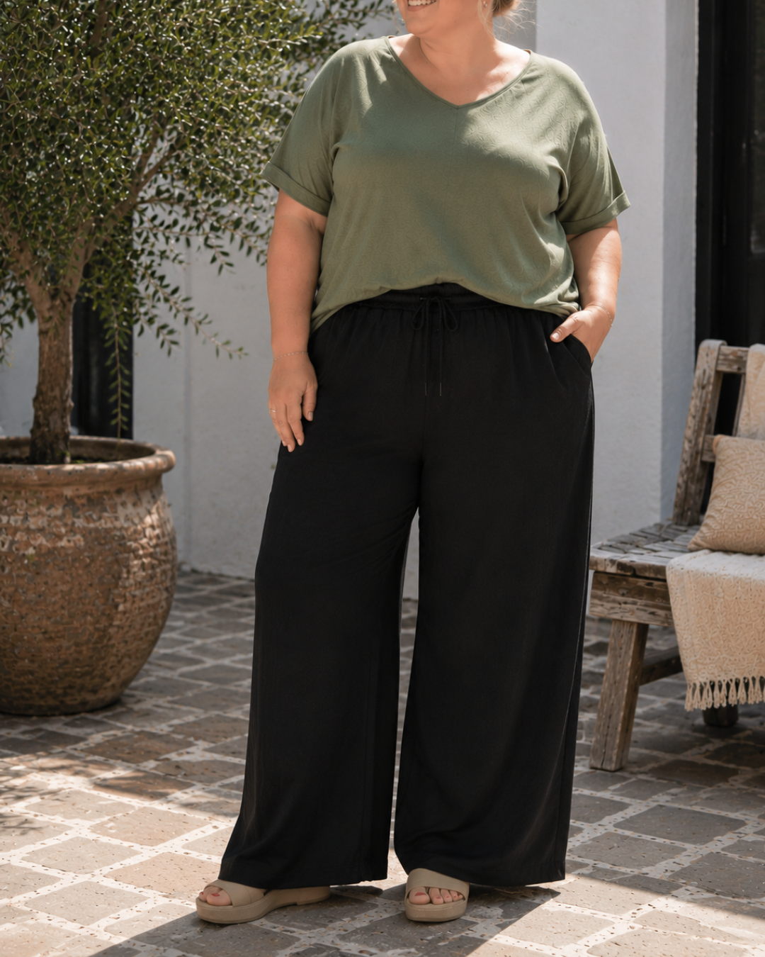 Smart plus size buks med brede ben. Den er med lommer og masser af stræk, som gør den behagelig. 

Billedet er genereret vha. AI.