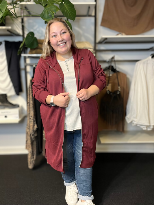 Smart plus size cardigan med lynlås og hætte. Den fås fra en str. 42 til og med str. 58. Den er fra Wasabi.