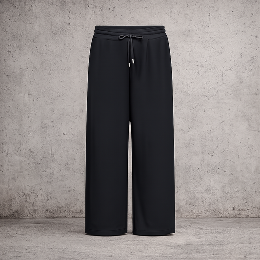 **Alt-tekst – Sabina 2 plussize buks (AI-genereret billede):**

AI-genereret billede af plus-size model i størrelse 50 iført sorte Sabina 2 bukser fra Wasabi. Bukserne har elastisk talje med bindebånd, lige brede ben og praktiske sidelommer. Modellen har bukserne stylet med en sort sweatshirt over en hvid skjorte og hvide sneakers. Billedet er taget udendørs foran en moderne bygning og viser buksernes afslappede pasform og komfortable look.
