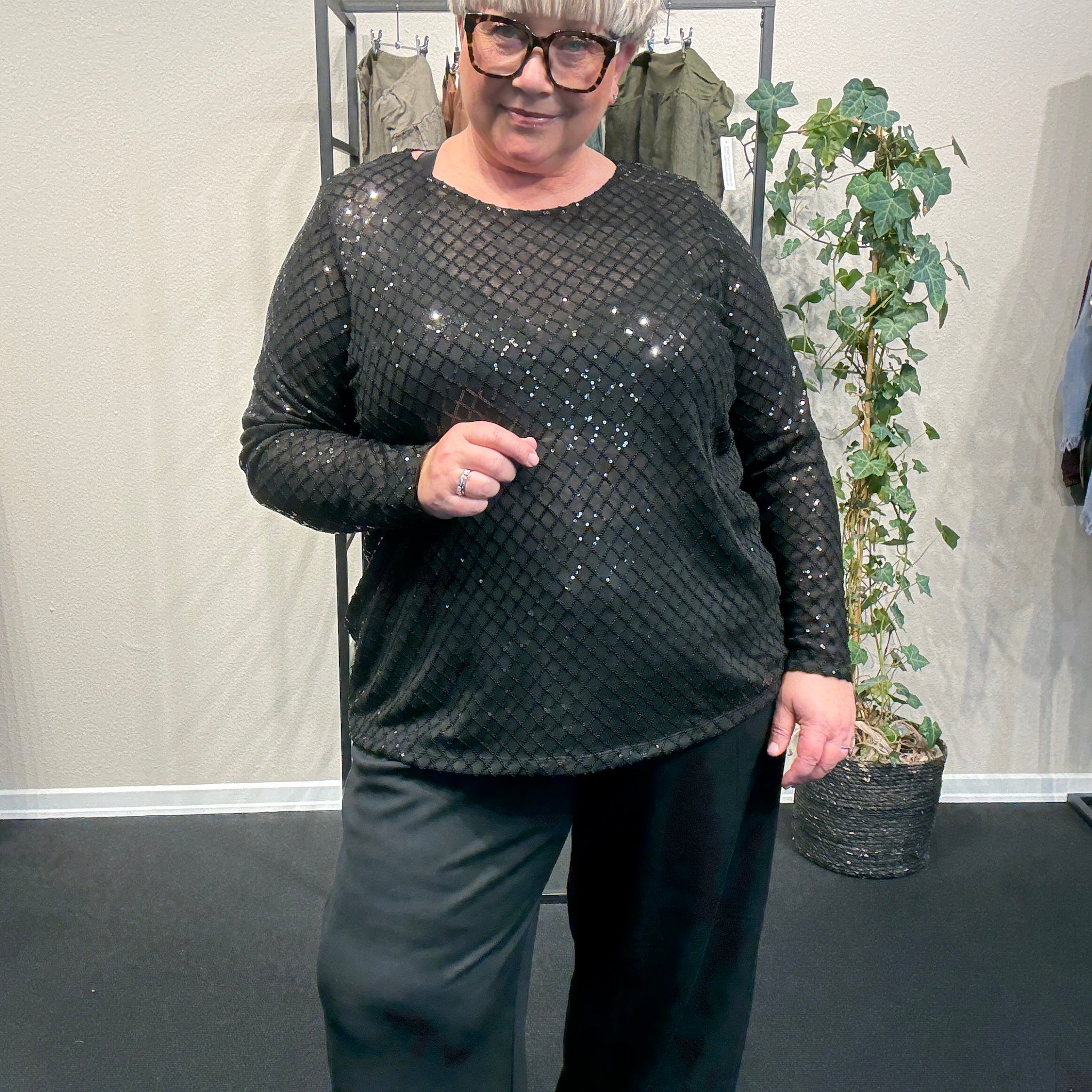 Plus size bluse i et flot paillet mønster. Den er med lange ærmer, rund hals og har en lille lykke i ryggen. Perfekt til årstidens fester. 