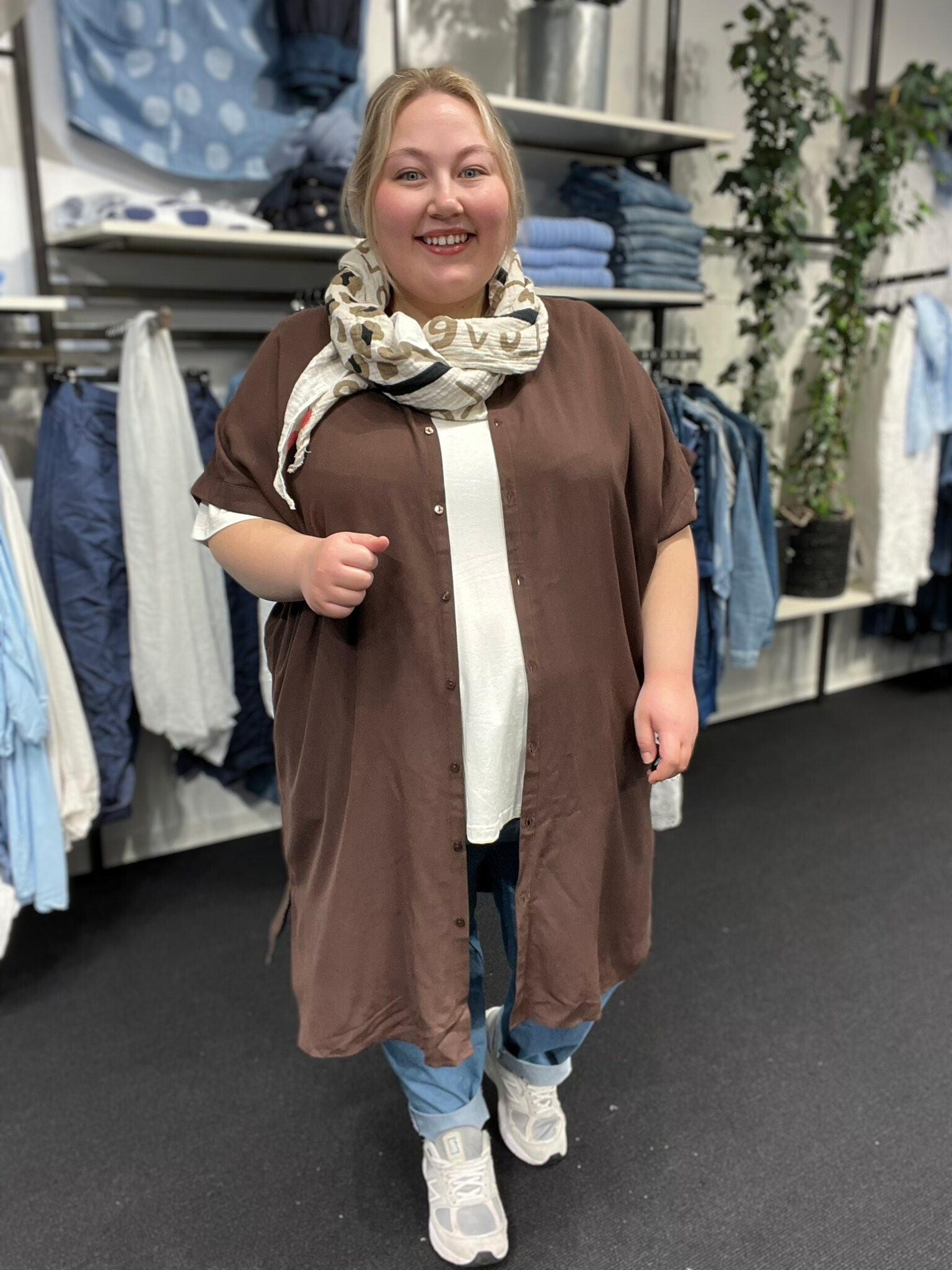 Sia 5 er en lang plus size skjorte, fra mærket Wasabi, modellen bruger den her som en åben jakke, men den kan også lukkes helt da den er gennemknappet. 