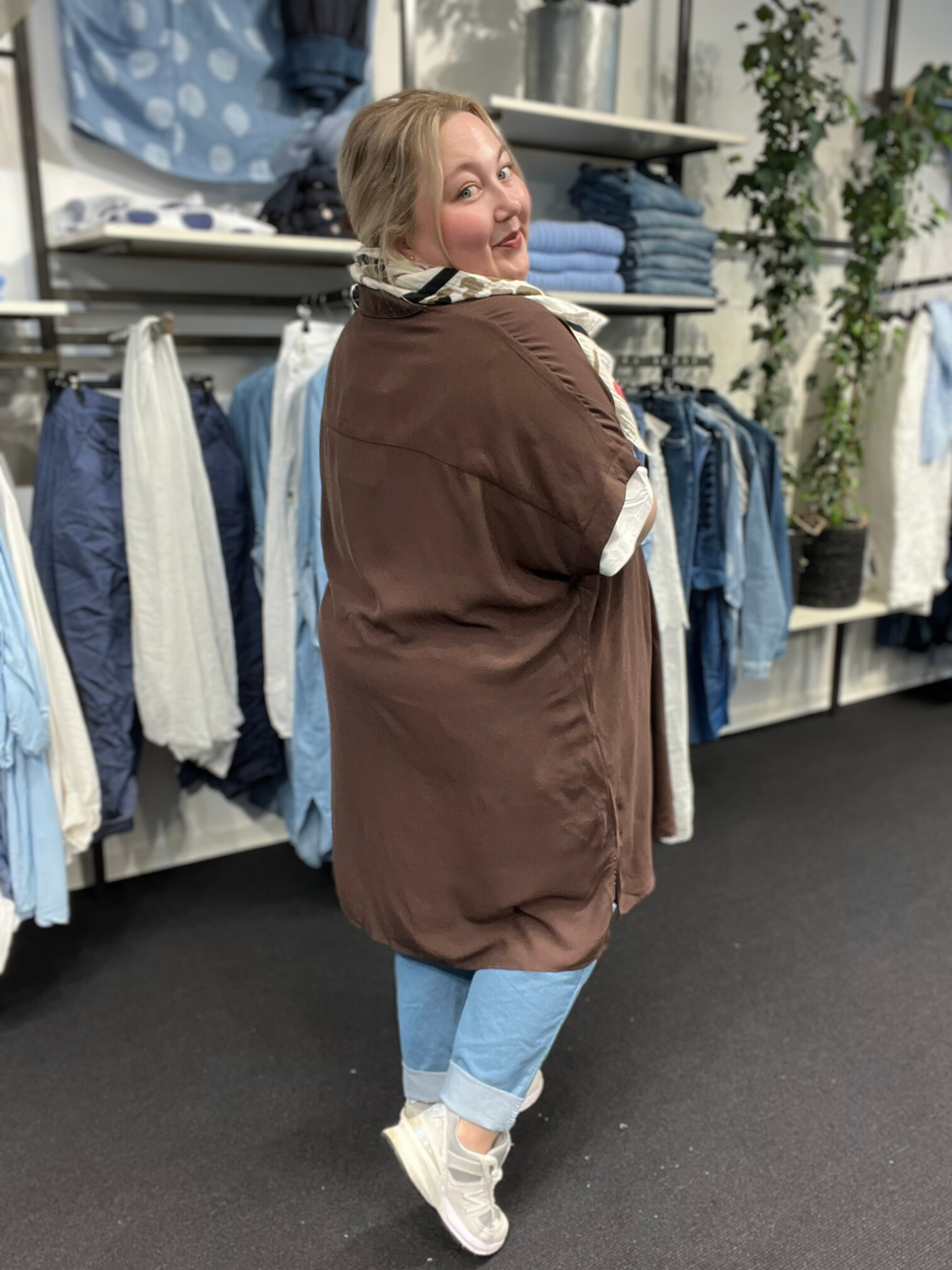 Sia 5 er en lang plus size skjorte, fra mærket Wasabi, modellen bruger den her som en åben jakke, men den kan også lukkes helt da den er gennemknappet. 